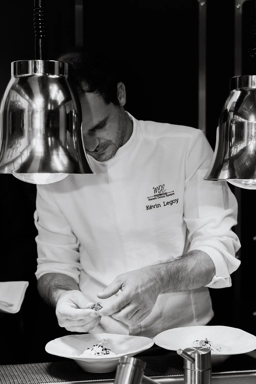 Le chef Kévin Legoy dressant les assiettes du dîner à Maison Douce Époque